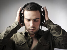 Mand i groen skjorte med sorte hoeretelefoner