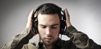 Mand i groen skjorte med sorte hoeretelefoner