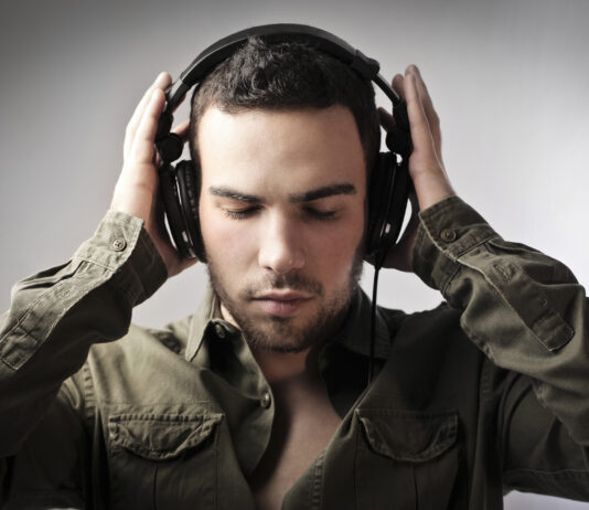 Mand i groen skjorte med sorte hoeretelefoner