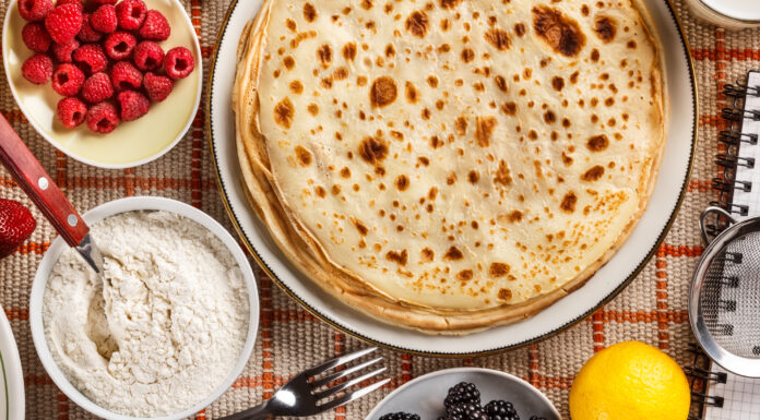 Pandekager – måske det mest alsidige mad i verden Pandekager paa bord med friske baer og sukker